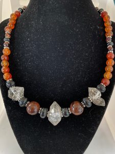 Red Tiger Eye, Herkimer Diamond, Jet, and Carnelian Necklace.

This necklace promotes Happiness, Courage, Psychic Development, and Protection. 